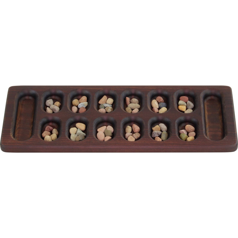 May include: A wooden game board with 12 small depressions, each filled with colorful stones. The board has two larger depressions on either end.