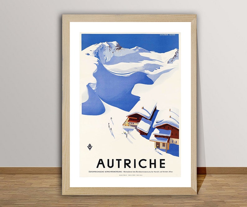 May include: A vintage travel poster advertising Austria. The poster features a snowy mountain scene with a blue sky and a small village of red-roofed houses. The text "AUTRICHE" is printed in black at the bottom of the poster.