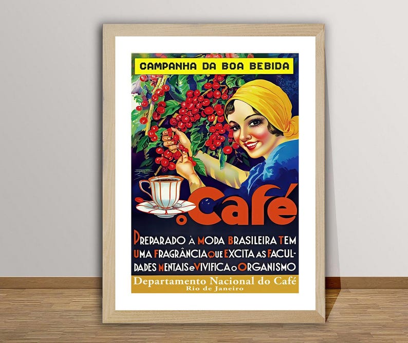 May include: A framed vintage coffee advertisement in Portuguese. It features a woman in a yellow headscarf with coffee cherries, a cup of coffee, and the word "Caf&eacute;". The poster has text in Portuguese and is framed in a light wood frame.