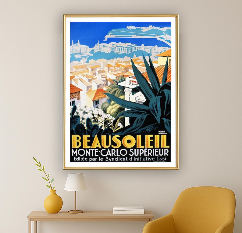 May include: A framed vintage travel poster for Beausoleil, Monte-Carlo Sup&eacute;rieur. The poster features a vibrant illustration of a coastal town with orange rooftops, blue sky, and dark green plants. The text is in yellow and black.