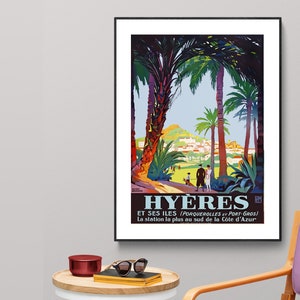 May include: A vintage travel poster advertising Hy&egrave;res, a town in the south of France, with the text "Hy&egrave;res et ses &icirc;les (Porquerolles et Port-Gros) La station la plus au sud de la C&ocirc;te d'Azur". The poster features a colourful illustration of palm trees, a hillside town, and people walking along a path.