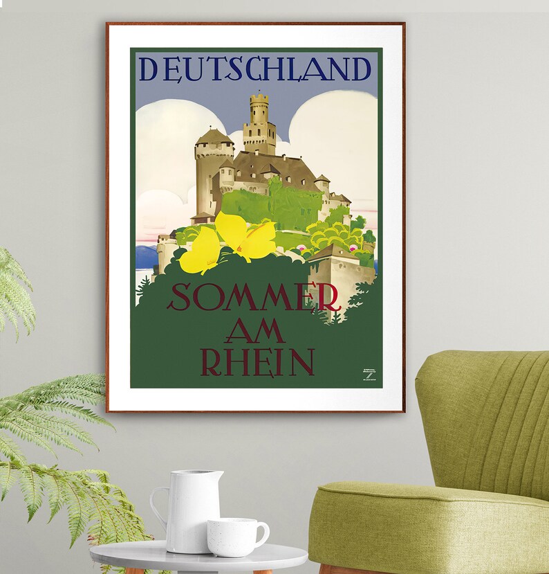 May include: A vintage travel poster advertising summer vacations in Germany. The poster features a picturesque castle nestled in a lush green landscape with a blue sky and fluffy white clouds. The text on the poster reads "DEUTSCHLAND SOMMER AM RHEIN".