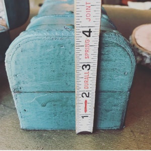 May include: A blue wooden box with a metal hinge and a ruler measuring 3 inches. The ruler is labeled "DURAL 3 SPRING 4 JOINT".