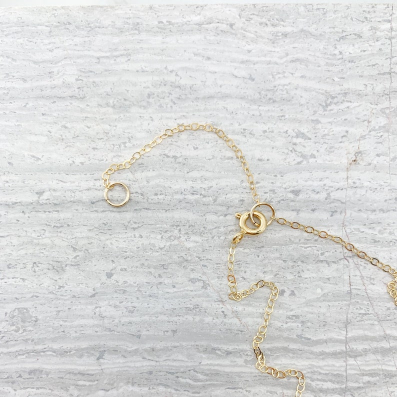 May include: A gold chain necklace with a lobster clasp closure. The chain is made of small, round links.