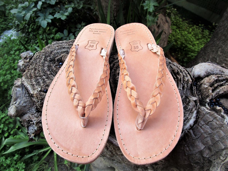 Pu&ograve; includere: Un paio di sandali in pelle color cuoio con cinturini intrecciati. I sandali hanno un design semplice e sono realizzati in pelle di alta qualit&agrave;. I sandali sono taglia 38.