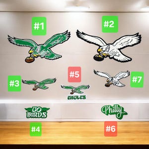 May include: Various Philadelphia Eagles-themed wall decals. The decals include green and white eagles in flight, holding footballs, and text that says "GO BIRDS" and "Philly".