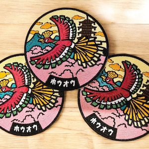 May include: Three round embroidered patches featuring a red phoenix in flight, set against a backdrop of mountains, clouds, and a pagoda. The patches have a black border and Japanese text.