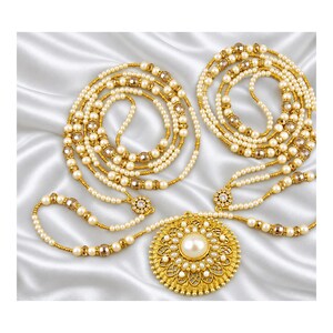 May include: A long multi-strand necklace featuring cream-colored pearls and gold-toned beads. The design includes a large, circular gold-toned pendant with an intricate filigree pattern, centered with a single large cream-colored pearl.