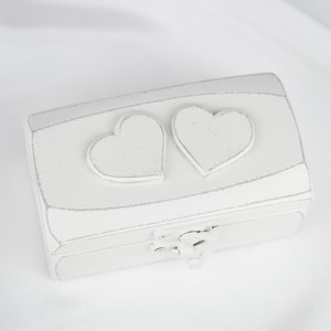 May include: White wooden box with two heart-shaped cutouts on the lid. The box has a distressed white finish and a hinged lid.