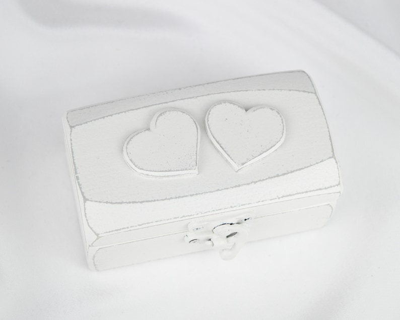 May include: White wooden box with two heart-shaped cutouts on the lid. The box has a distressed white finish and a hinged lid.