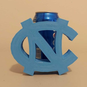 May include: A light blue 3D printed can holder shaped like the letters "NC". A blue can of soda is inside the holder.