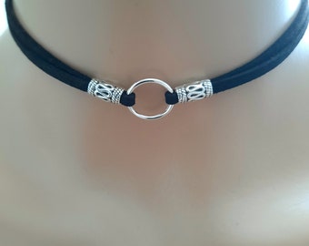 May include: A black suede choker necklace with a silver ring and decorative accents.