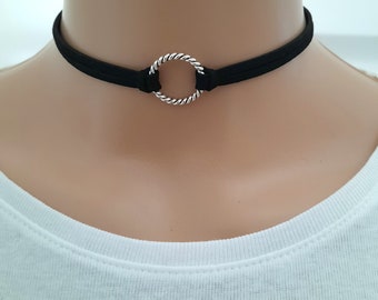 May include: A black choker necklace with a silver twisted circle pendant.