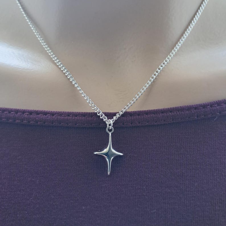 A simple silver coloured star charm hangs from a silver plated fine curb chain necklace. The necklace is available in several different lengths and is finished with a lobster clasp. Supplied in an organza gift bag ready to gift to someone special.
