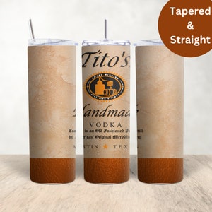 Pu&ograve; includere: Un bicchiere in acciaio inossidabile con un design marrone e beige che presenta il logo della vodka artigianale Tito's. Il bicchiere &egrave; affusolato e ha una cannuccia.