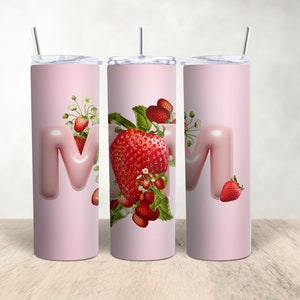 Könnte beinhalten: Drei rosa Edelstahlbecher mit einem rosa Buchstaben "M" und Erdbeer-Designs.
