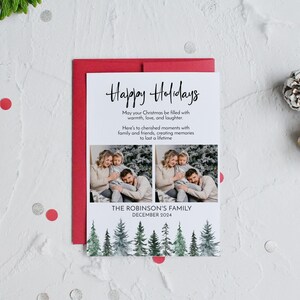 Puede incluir: Una tarjeta de Navidad blanca con una ilustraci&oacute;n de acuarela de un bosque. La tarjeta presenta una foto de una familia de tres personas, con el texto "Felices Fiestas" y "The Robinson's Family, diciembre de 2024".