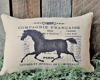 May include: A beige pillow with a black silhouette of a horse running on a vintage French document. The text on the document reads "Compagnie Française" and "Lettres et Journal de la Montagne".