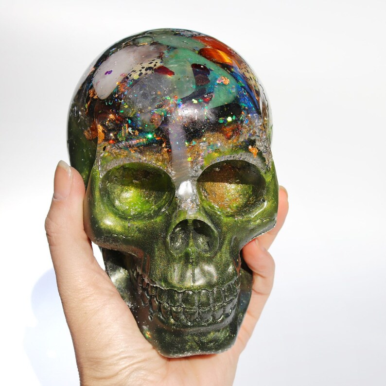 May include: Green skull-shaped resin sculpture with embedded colorful crystals and glitter.