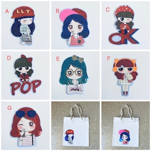 May include: A set of 9 iron-on patches featuring cartoon girls with different outfits and accessories. The patches are colorful and have a sparkly, sequined texture. The patches include the words "LLY", "POP", and "OK".