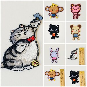 May include: A set of 10 iron-on embroidered patches featuring various cute animal designs, including a cat, a monkey, a rabbit, a cat with a butterfly, a black cat, a brown bear, a pink cat, and a gray cat. The patches are perfect for adding a touch of whimsy to clothing, bags, or other fabric items.