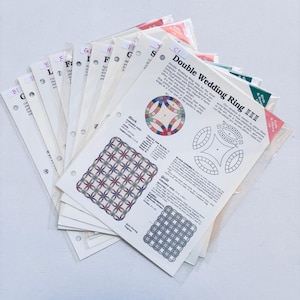 May include: A stack of quilting pattern instructions for a double wedding ring quilt. The pattern includes a color diagram of the quilt block and instructions for piecing the quilt.