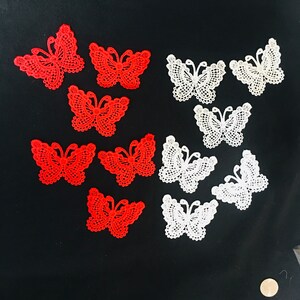 May include: Assortment of red and white lace butterfly appliques. The appliques are delicate and intricate, with a variety of sizes and shapes.