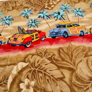 May include: A brown and tan fabric with a tropical print of palm trees and surfboards. Two vintage wood-paneled station wagons are driving on a red road with a blue sky in the background.