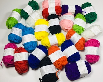 May include: A collection of colorful yarn skeins in various shades of blue, green, red, yellow, orange, pink, purple, white, and black. The yarn is wrapped around cardboard spools with white labels.