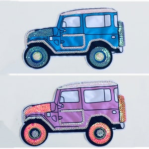 May include: Two sequined iron-on patches of a blue and pink jeep. The patches are perfect for adding a fun and unique touch to clothing, bags, or other fabric items.