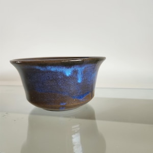 Vintage studio pottery ceramic bowl with beautiful blue and brown glaze that has almost an iridescent quality.