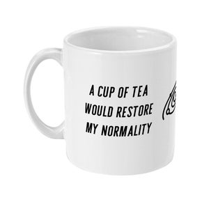 Puede incluir: Taza de cerámica blanca con asa curva. La taza presenta texto negro que dice: «A CUP OF TEA WOULD RESTORE MY NORMALITY». Un pequeño gráfico está a la derecha del texto. Ideal para té o café.