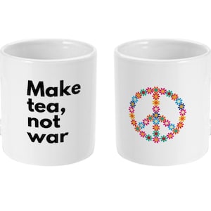 May include: Two white ceramic mugs with a peace sign and the text "Make tea, not war" printed on them.
