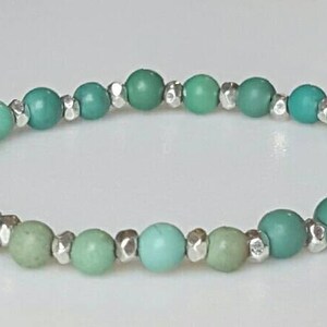 May include: A turquoise and green beaded bracelet with silver accents.