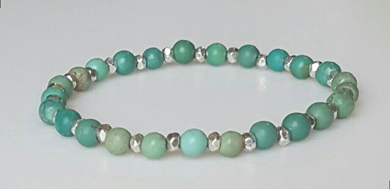 May include: A turquoise and green beaded bracelet with silver accents.