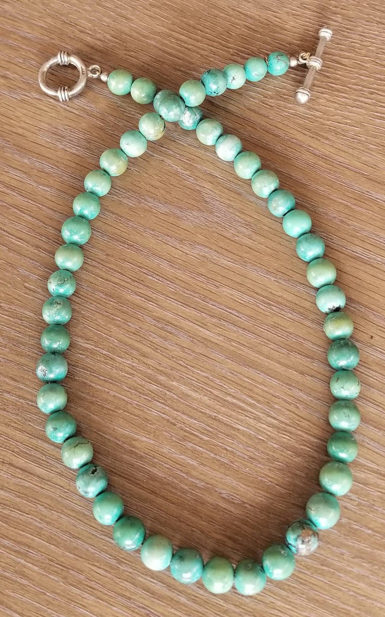 May include: A turquoise beaded necklace with a silver clasp and toggle closure.