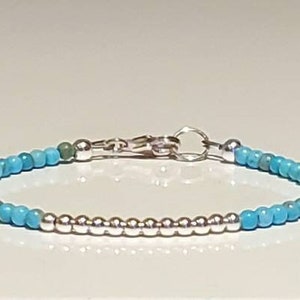 May include: A turquoise and silver beaded bracelet with a silver clasp.