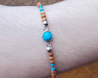 May include: A turquoise gemstone bracelet with wooden beads and silver accents.