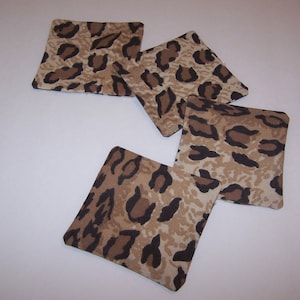 May include: Four brown and black leopard print fabric coasters.