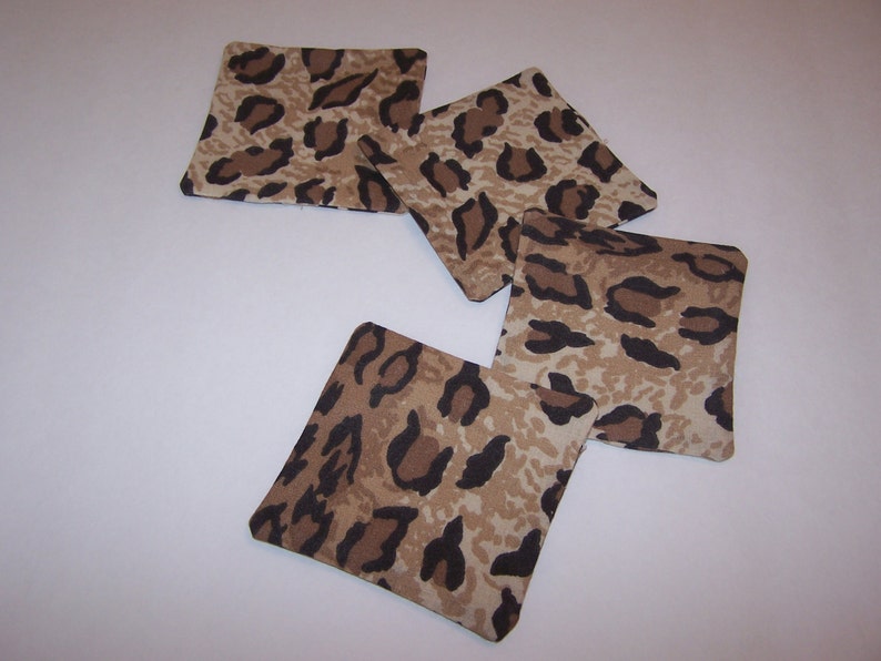 May include: Four brown and black leopard print fabric coasters.