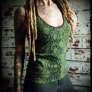 May include: A green tank top with a snake skin pattern. The tank top has a black trim around the neckline.