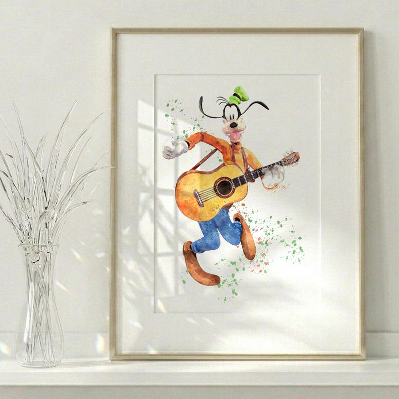 Puede incluir: Una l&aacute;mina enmarcada en acuarela que muestra al personaje de dibujos animados Goofy tocando una guitarra ac&uacute;stica. El personaje viste un su&eacute;ter naranja, pantalones azules y un sombrero verde, con salpicaduras de pintura de colores.