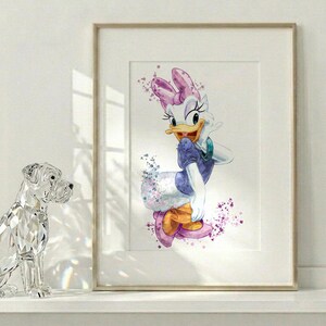Puede incluir: Una l&aacute;mina de arte mural enmarcada con una ilustraci&oacute;n en acuarela de Daisy Duck. El personaje lleva un top morado, un lazo rosa y zapatos naranjas, rodeado de salpicaduras de pintura morada y rosa sobre un fondo blanco en un marco claro.