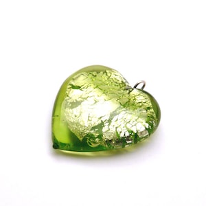 May include: A green glass heart pendant with silver leaf accents. The pendant has a silver loop for hanging.