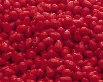 May include: A large pile of bright red glass beads in a teardrop shape.
