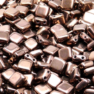May include: A close-up of a pile of small, square, copper-colored glass beads. The beads have a shiny, metallic finish and are perfect for jewelry making.