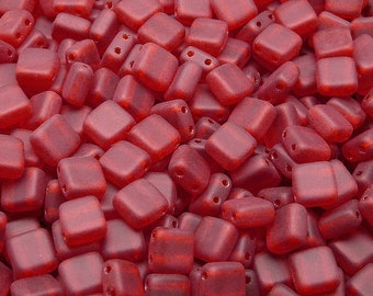 May include: A close-up image of a pile of small, square, red glass beads. The beads have a frosted finish and are perfect for jewelry making.