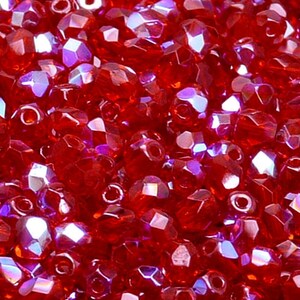 Könnte beinhalten: Nahaufnahme eines Haufens roter, irisierender Glasperlen. Die Perlen sind facettiert und haben eine glänzende Oberfläche.