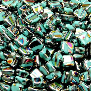 May include: A large pile of turquoise blue square glass beads with iridescent silver accents. The beads have two holes for stringing.