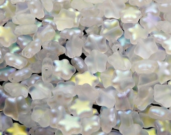May include: A close-up of a pile of iridescent white glass beads in the shape of stars. The beads have a subtle shimmer and are perfect for jewelry making.